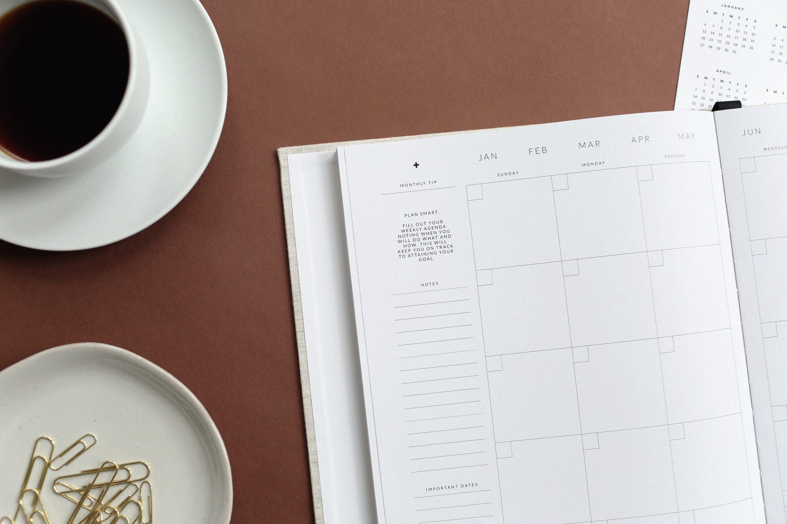 coffee and blank planner on a desk